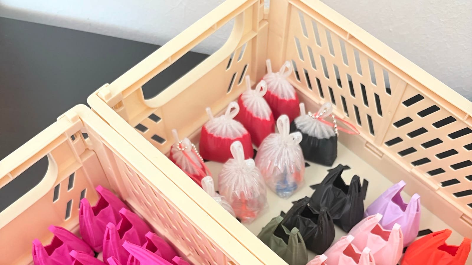 Crate of hot pink plastic bag keychains ready for a bulk order
