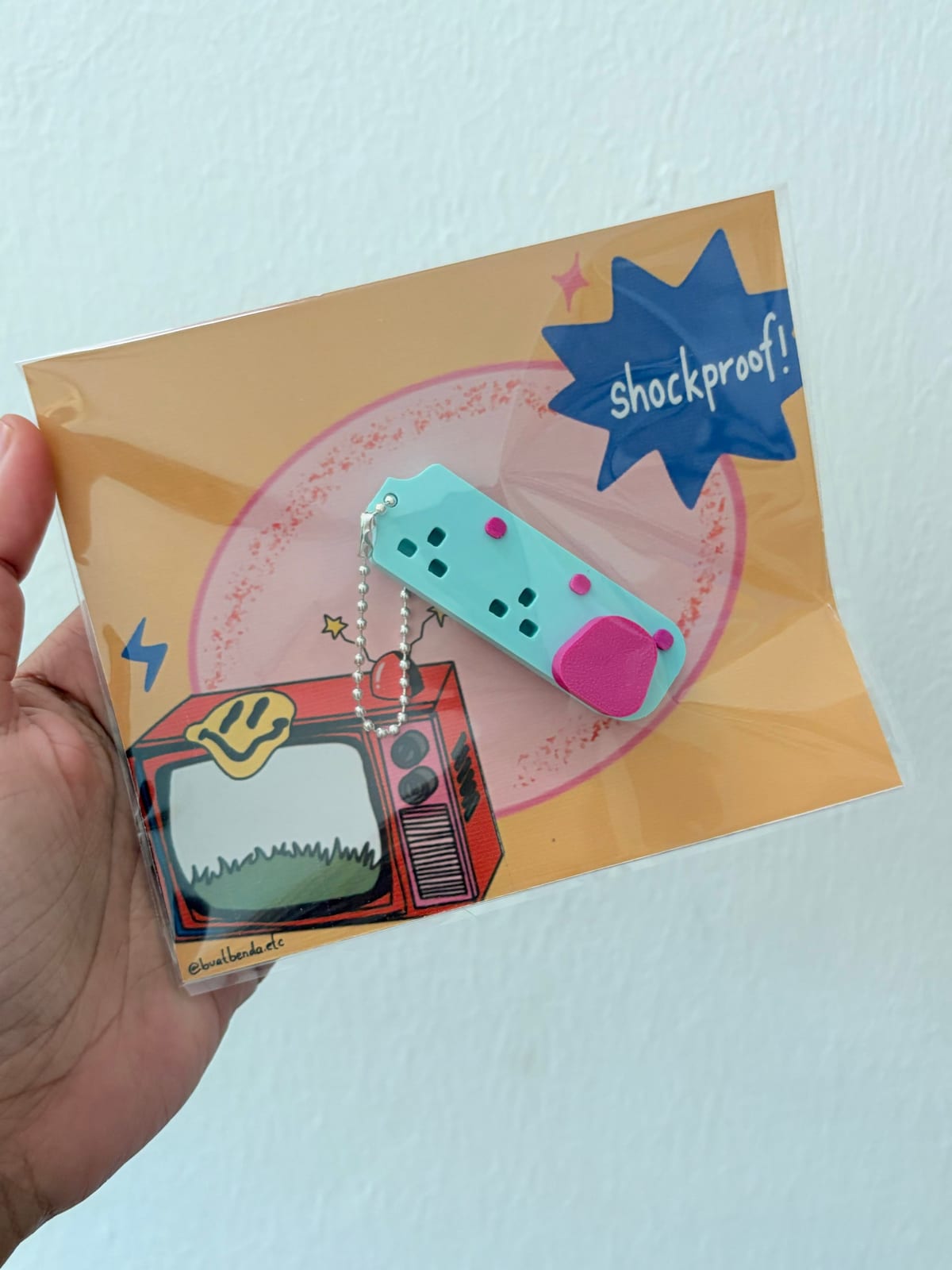 Extension plug keychain packed in its card sleeve
