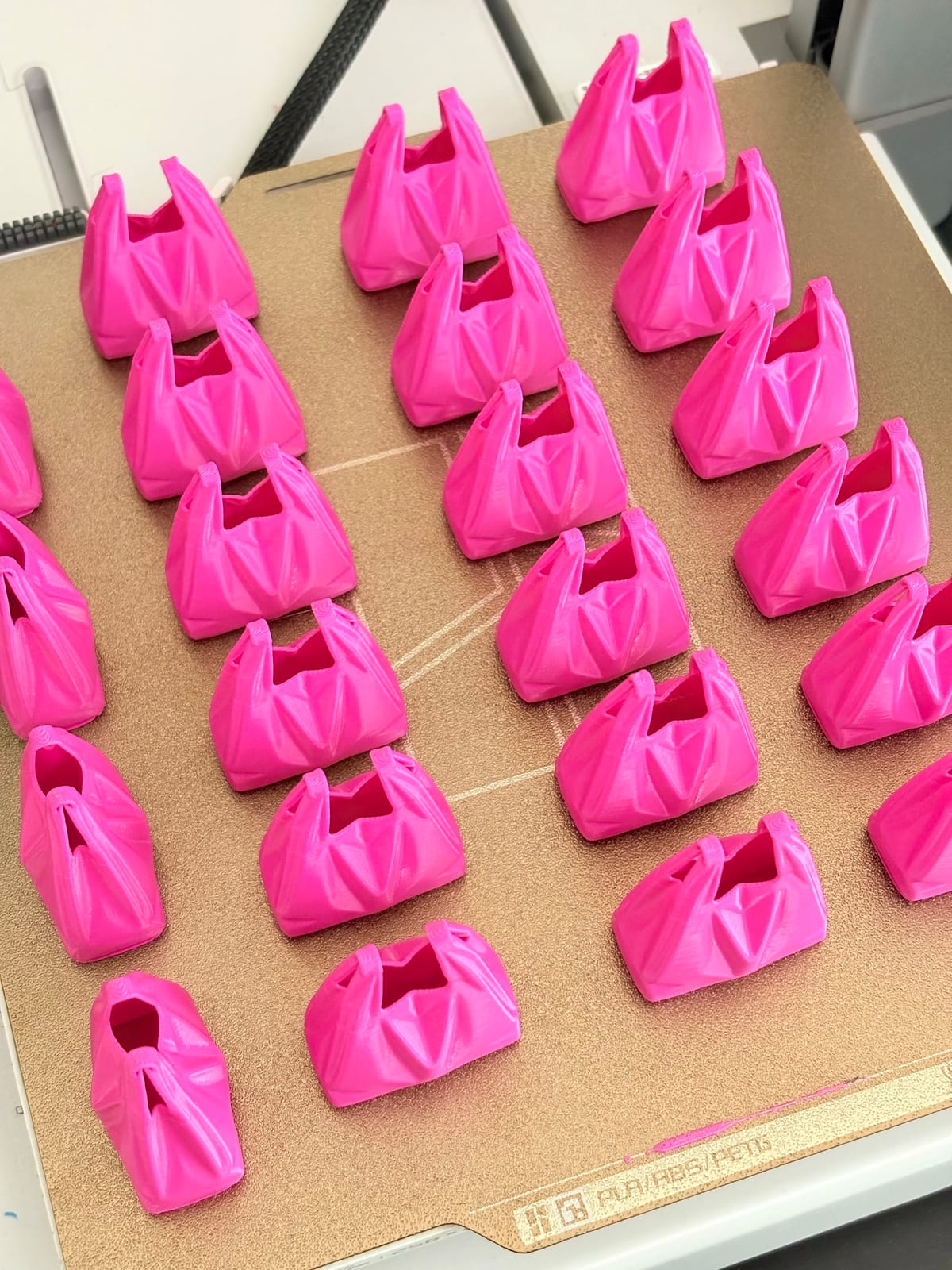 Rows of hot pink plastic bag keychains for a bulk order